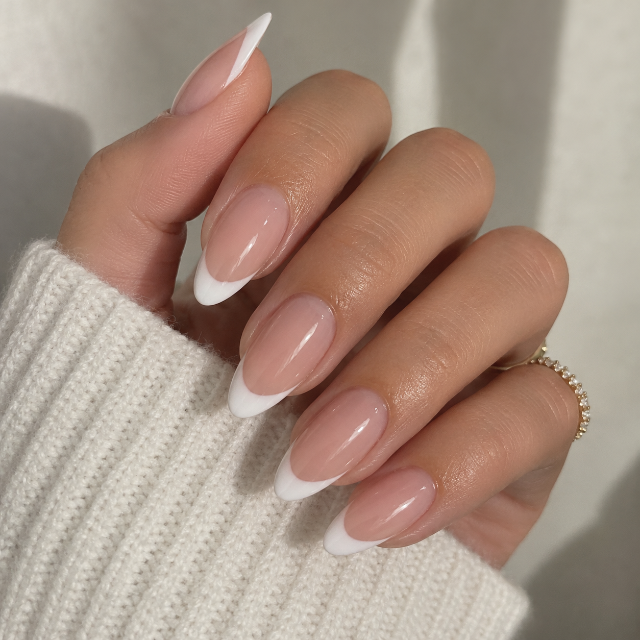 Almond press-on nails with white French tips, worn by Amara
